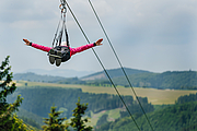 Ferienwelt Winterberg / Stephan Peters Einen Person fliegt an einer Zipline ins Tal