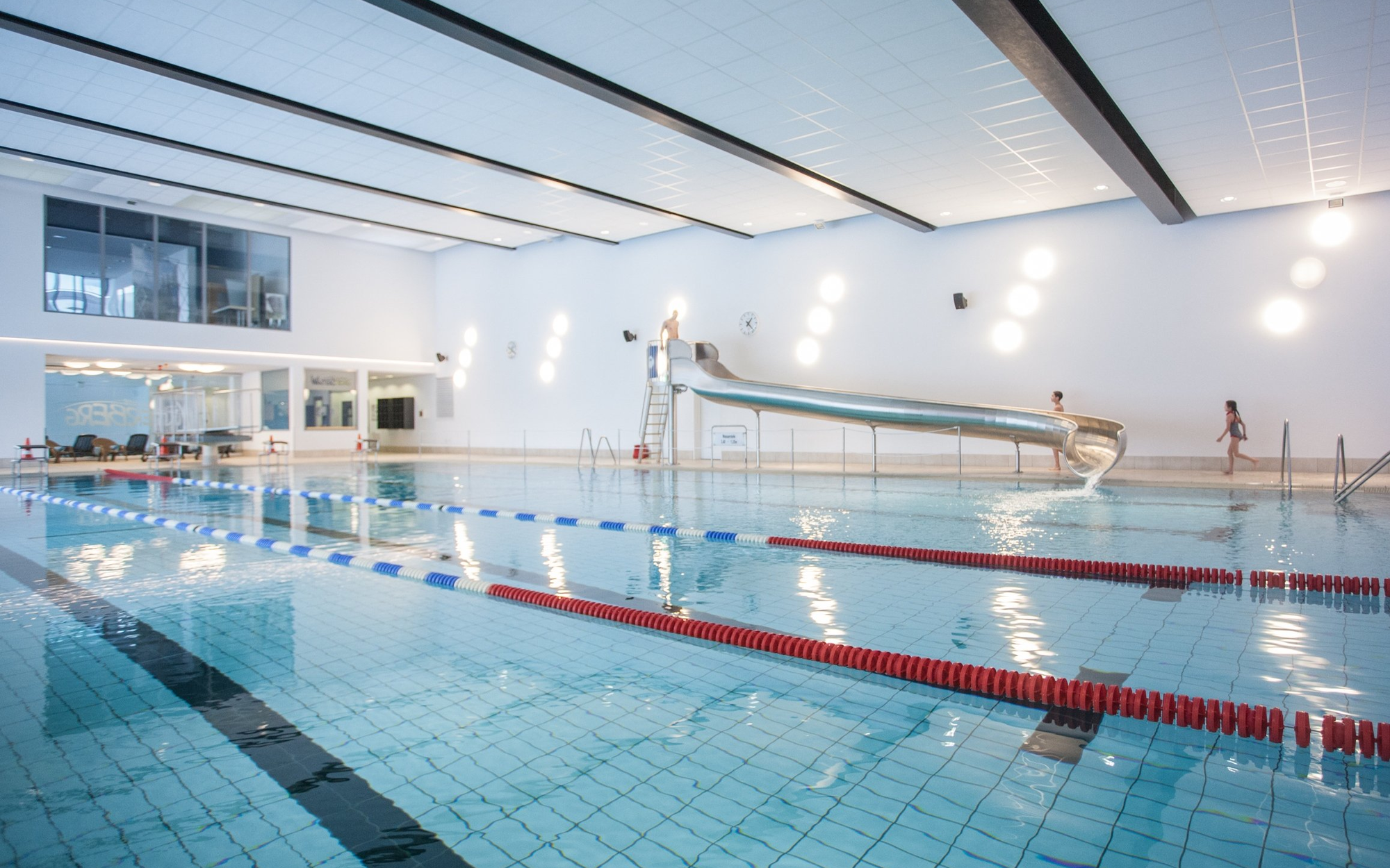 Das Sportbecken mit Wasserrutsche, Sprungbrett und Startblöcken im Schwimmbad Winterberg.