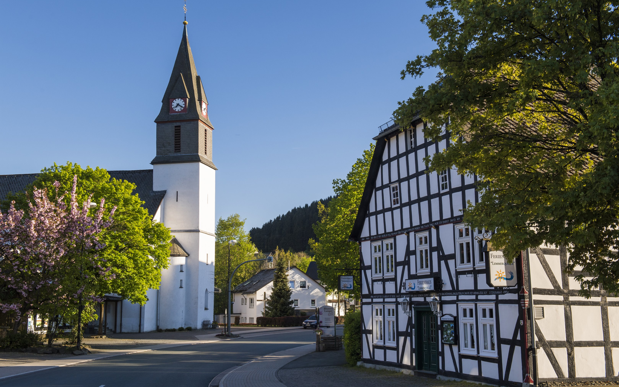 Die Ortsdruchfahrt der Ortschaft Niedersfeld mit Kirche und Fachwerkhaus.