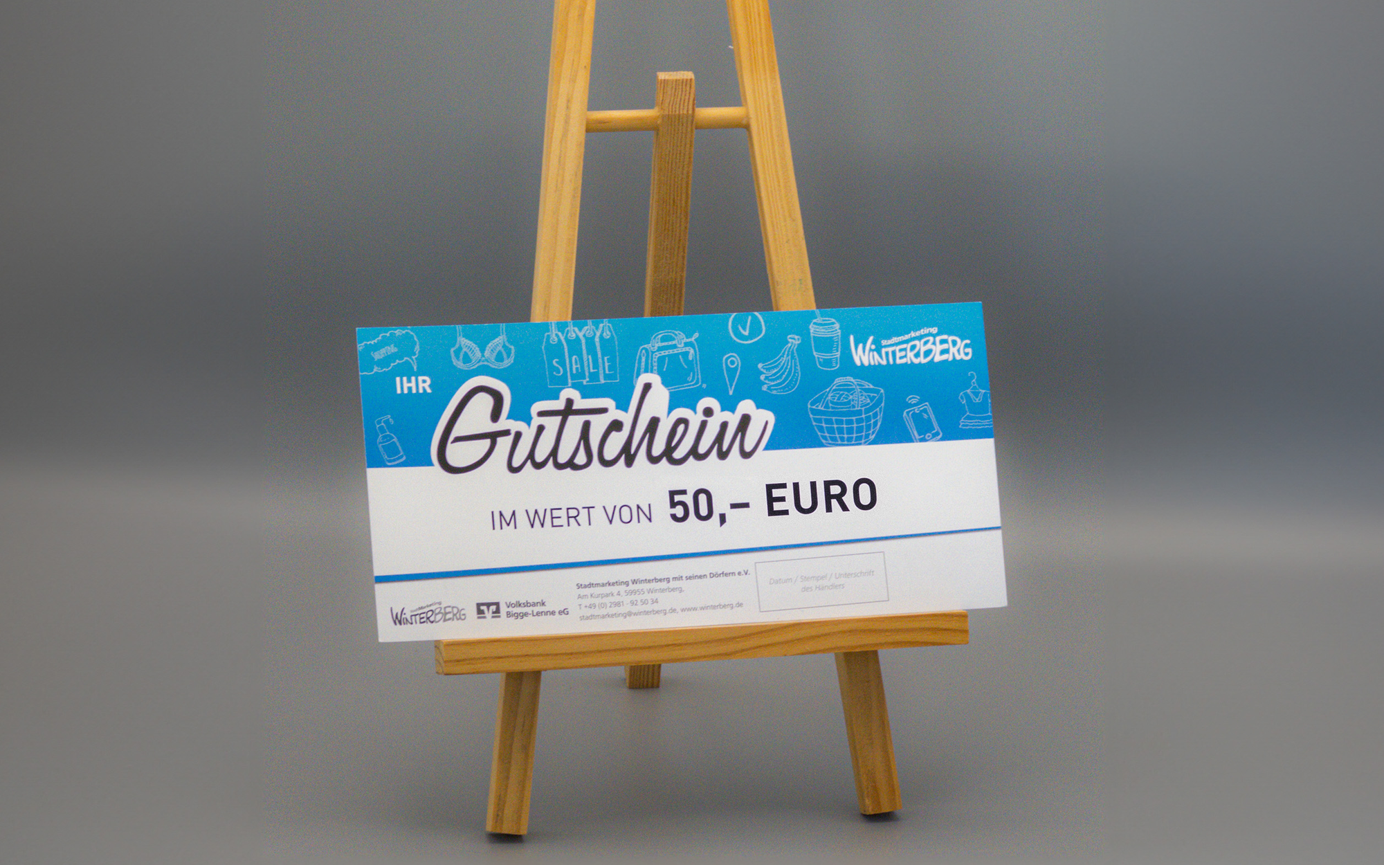 Ein Winterberg Gutschein im Wert von 50 Euro auf einer kleinen Staffelei.