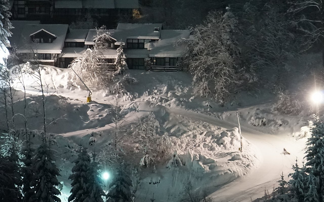 Die von Schnee bedeckte Rodelbahn in der Dunkelheit.