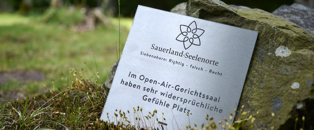 Schild mit der Aufschrift Sauerland Seelenorte Siebenahorn richtig - falsch - Recht. Im Open-Air-Gerichtssaal haben sehr widersprüchliche Gefühle Platz.