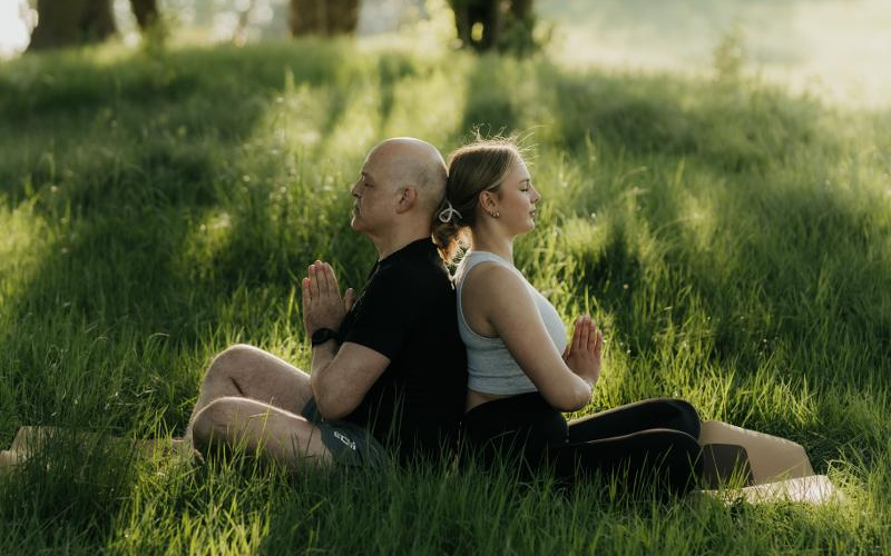 Zwei Menschen in einer Yoga Pose auf einer Winterberger Bergwiese Zwei Menschen in einer Yoga Pose auf einer Winterberger Bergwiese