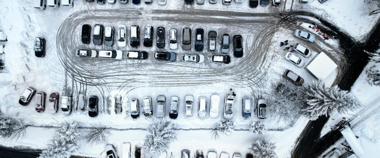 Ein Parkplatz im Winter aus der Vogelperspektive.