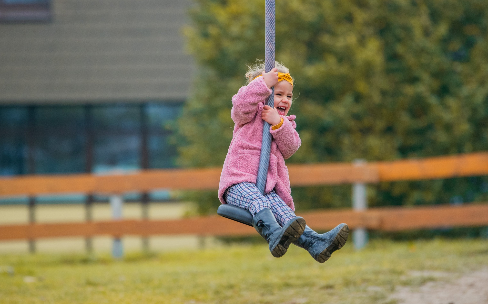 Kleines Mädchen lachend auf einer Seilrutsche auf dem Spielplatz
