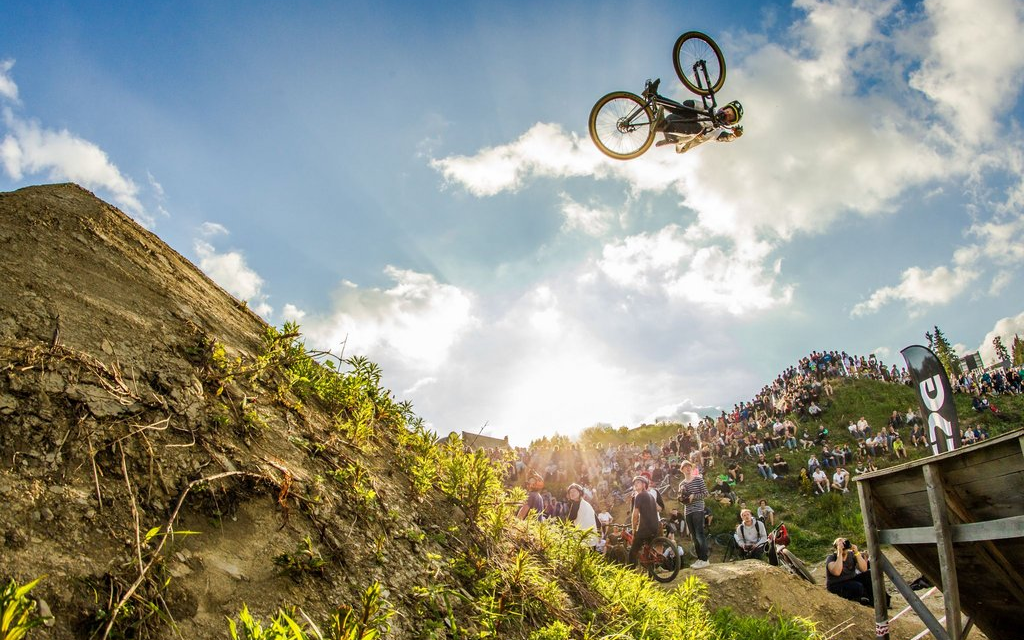 Ein Biker macht mit seinem Bike einen gewagten Sprung mit Salto von einer Rampe.