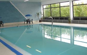 Das Schwimmbecken im Hallenbad Hallenberg mit Sitzgelegenheiten.