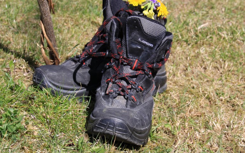 Ein Paar Wanderschuhe mit Sommerblumen geschmückt.