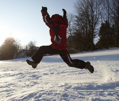 Ein Junge springt durch den Schnee