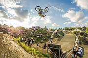 Ein Biker macht mit seinem Bike einen Salto von einer Rampe.