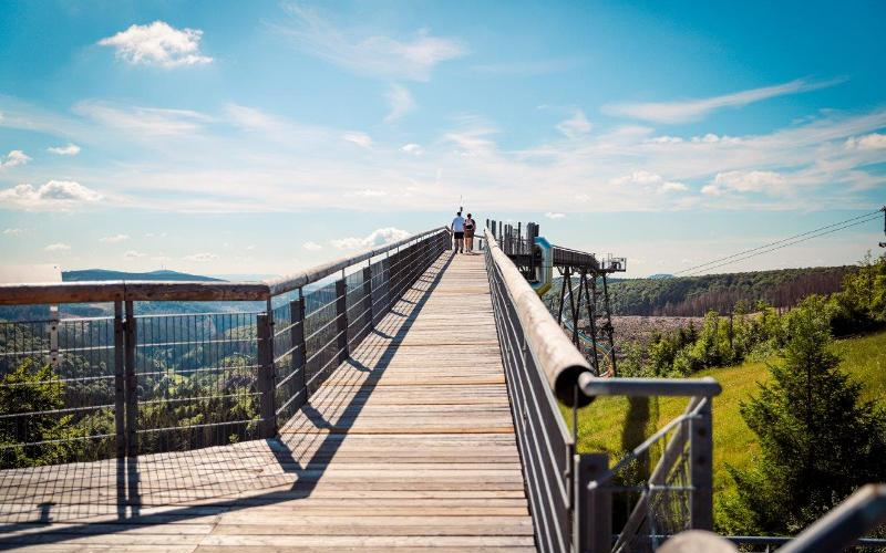 Zwei Personen gehen über die Panorama Erlebnisbrücke und genießen die Aussicht.