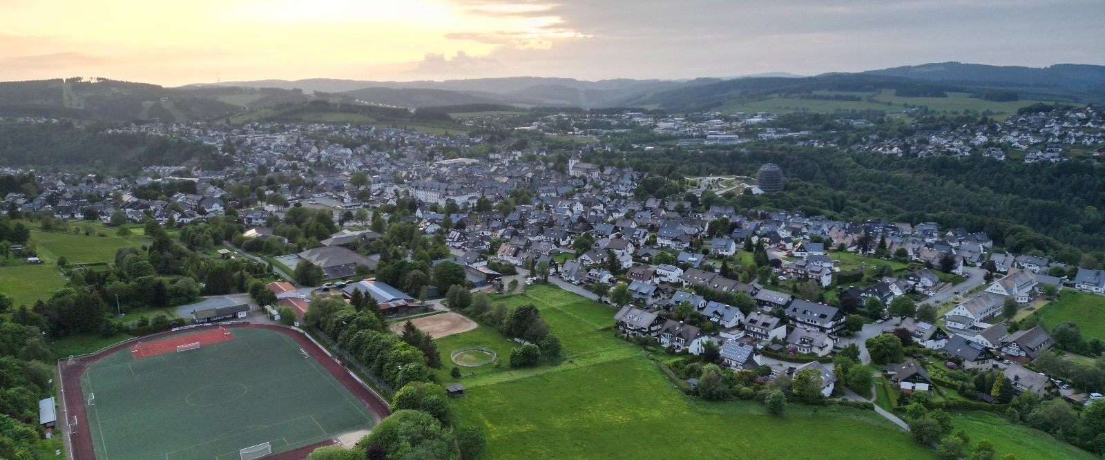 Drohnenaufnahme vom Sportplatz und einem Teil der Stadt Winterberg.