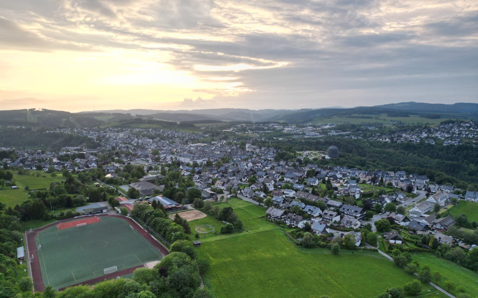 Drohnenaufnahme vom Sportplatz und einem Teil der Stadt Winterberg.
