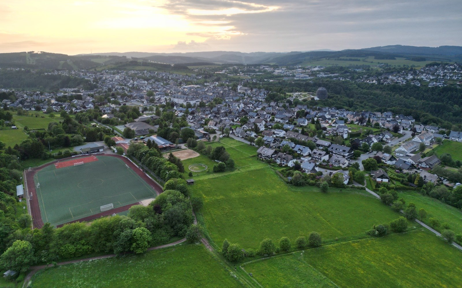 Drohnenaufnahme vom Sportplatz und einem Teil der Stadt Winterberg.